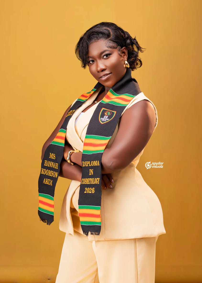 A woman wearing the Heritage sash in green, gold and red, embroidered in gold thread.